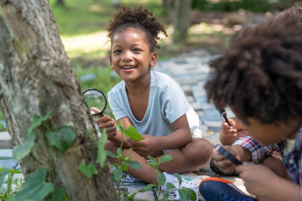 little girl outside with a magnifying glass