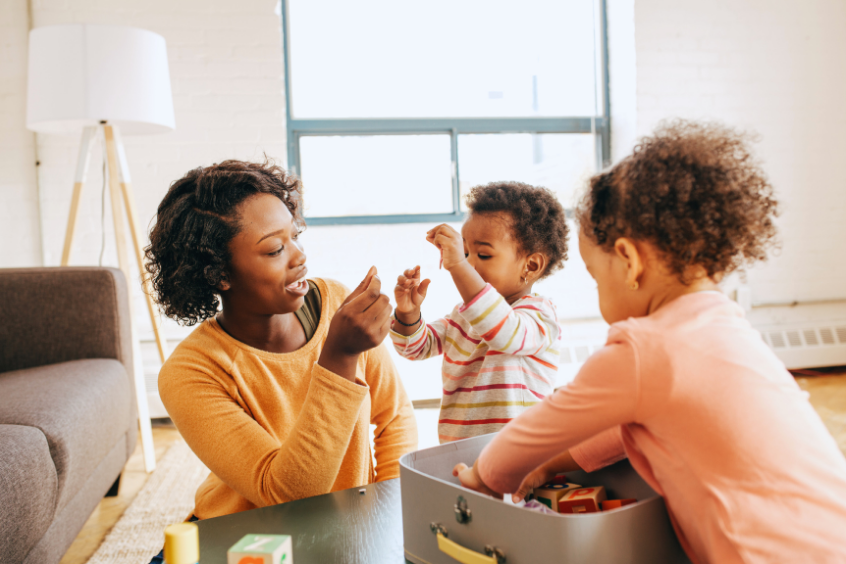 A mother of two playing with her kids with toys at home