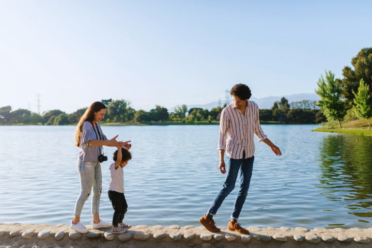 A joyful family enjoying quality time walking by the scenic lake on a sunny day